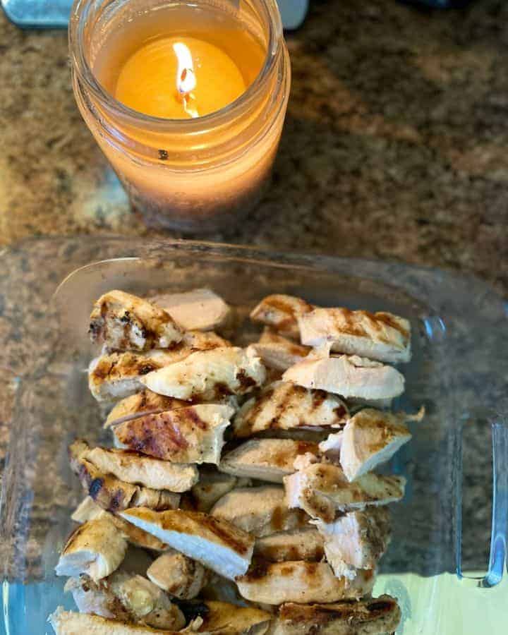 chicken strips in pan nest to candle being used in a frugal and simple way to use leftovers