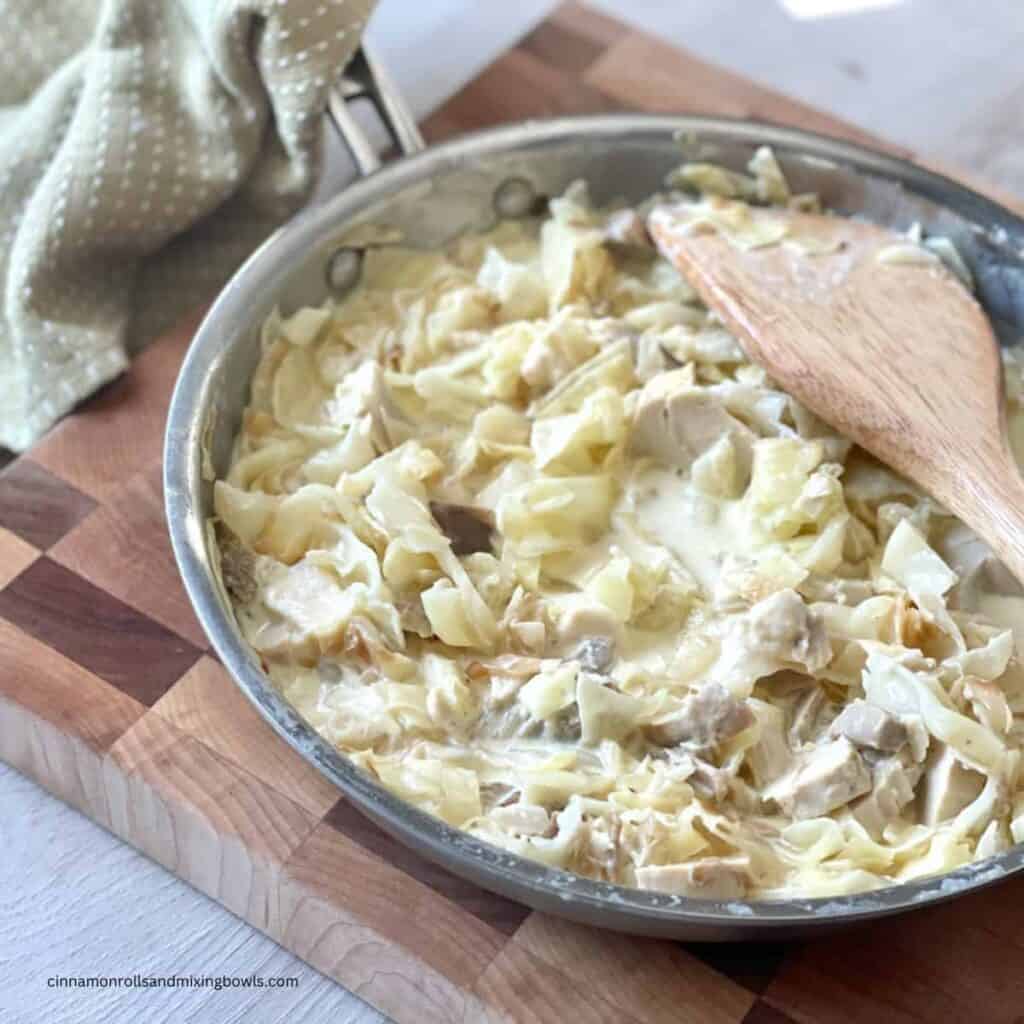 low carb creamy cabbage in skillet on cutting board to serve