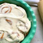 baked Kamut pumpkin pie cinnamon rolls in dish with frosting
