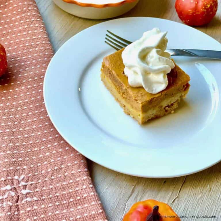 Kamut pumpkin pie bars served on plate with a dollop of whip cream