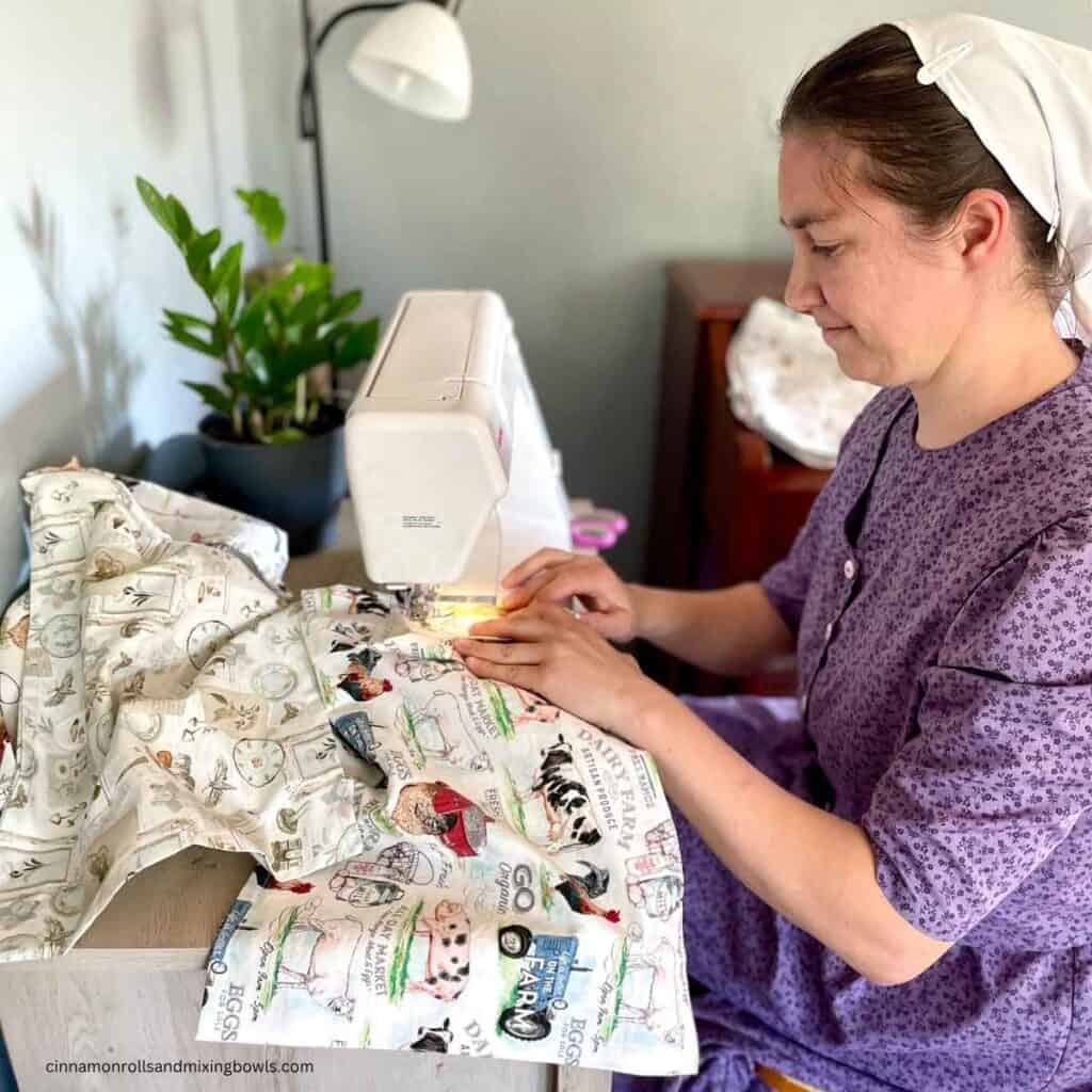 woman sitting at sewing machine desk sewing beeswax bread bags