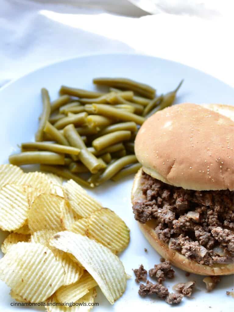 Healthy sloppy Joes sitting on a plate with a bun and chips