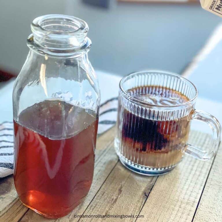 jar of no sugar maple coffee syrup with coffee cup next to it