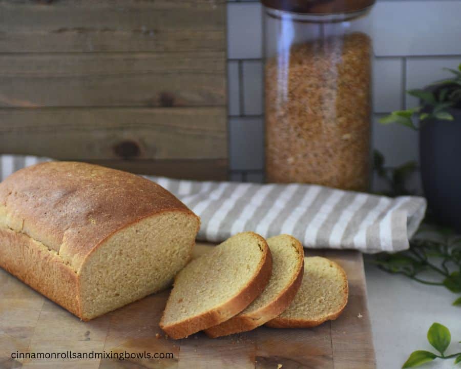 fresh milled kamut bread loaf sliced on cutting board with kamut grain in background 