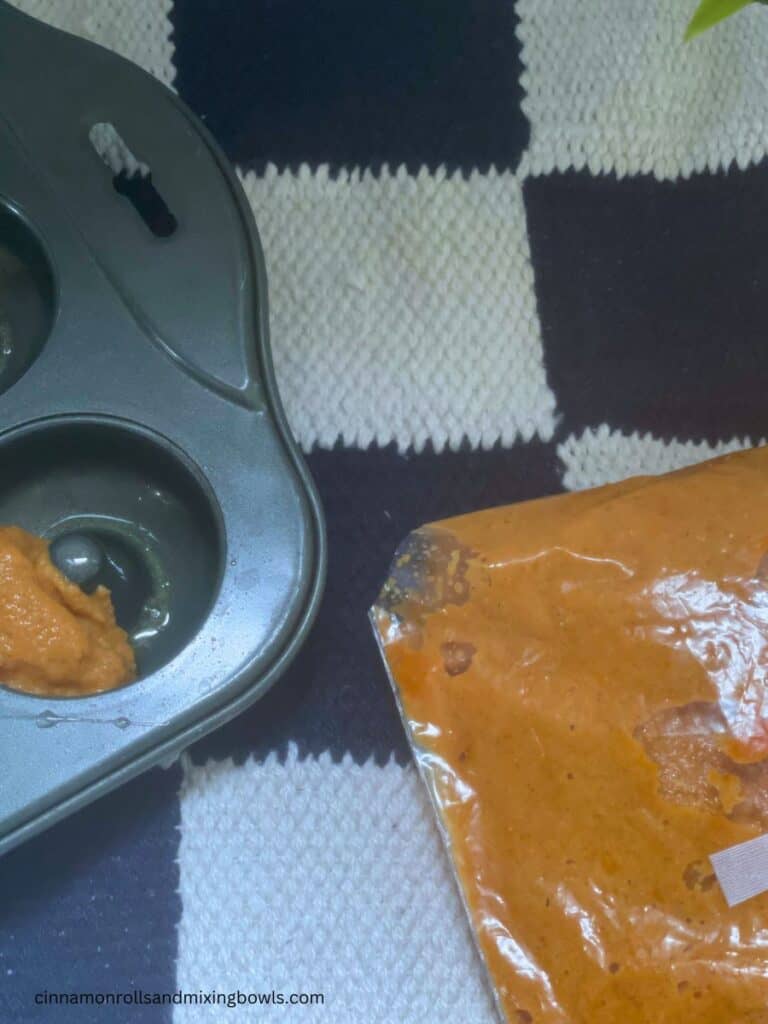dough for pumpkin cake donuts in a ziplock bag with a hole cut in the corner to pipe into donut pan for baked donuts 
